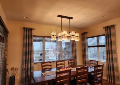 A dining room with hardwood floors and a chandelier.