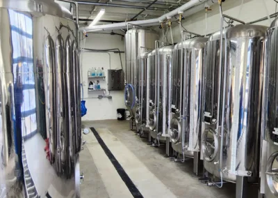 A line of stainless steel tanks in a room.