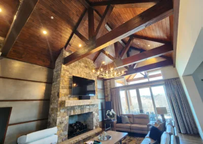 A living room with wood beams and a fireplace.