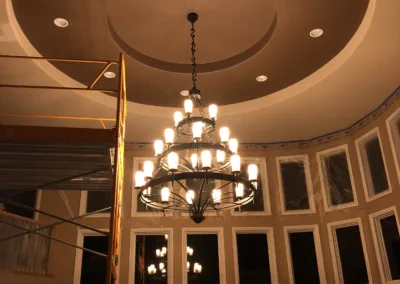 A chandelier is hanging in a room that is being remodeled.